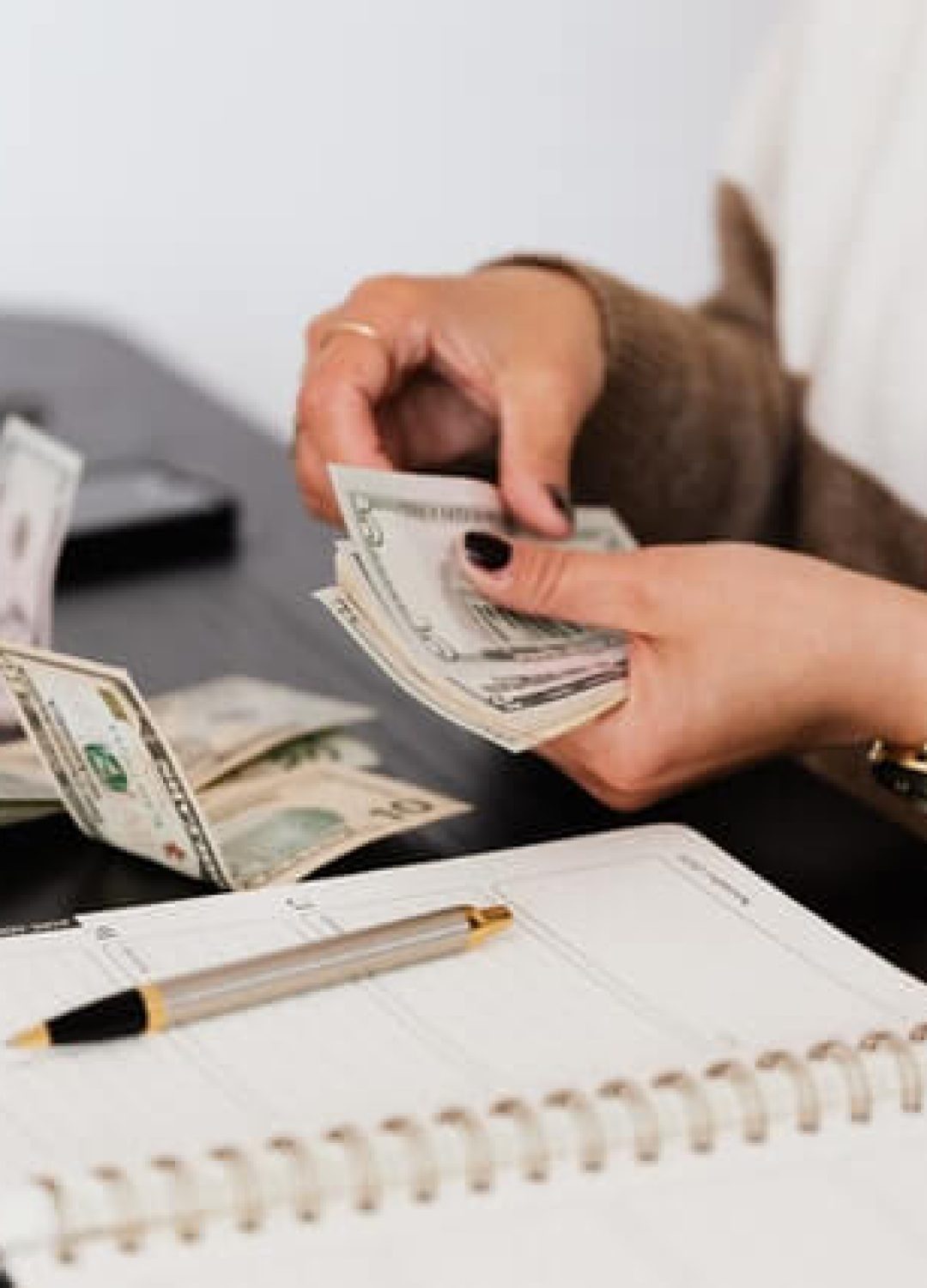 crop-payroll-clerk-counting-money-while-sitting-at-table