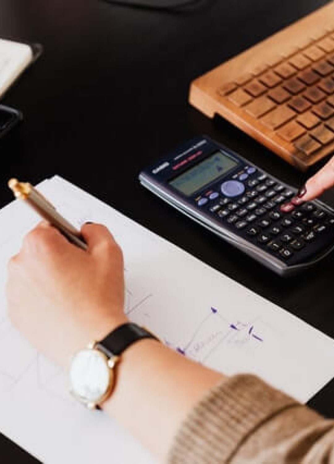 crop-woman-using-calculator-and-taking-notes-on-paper